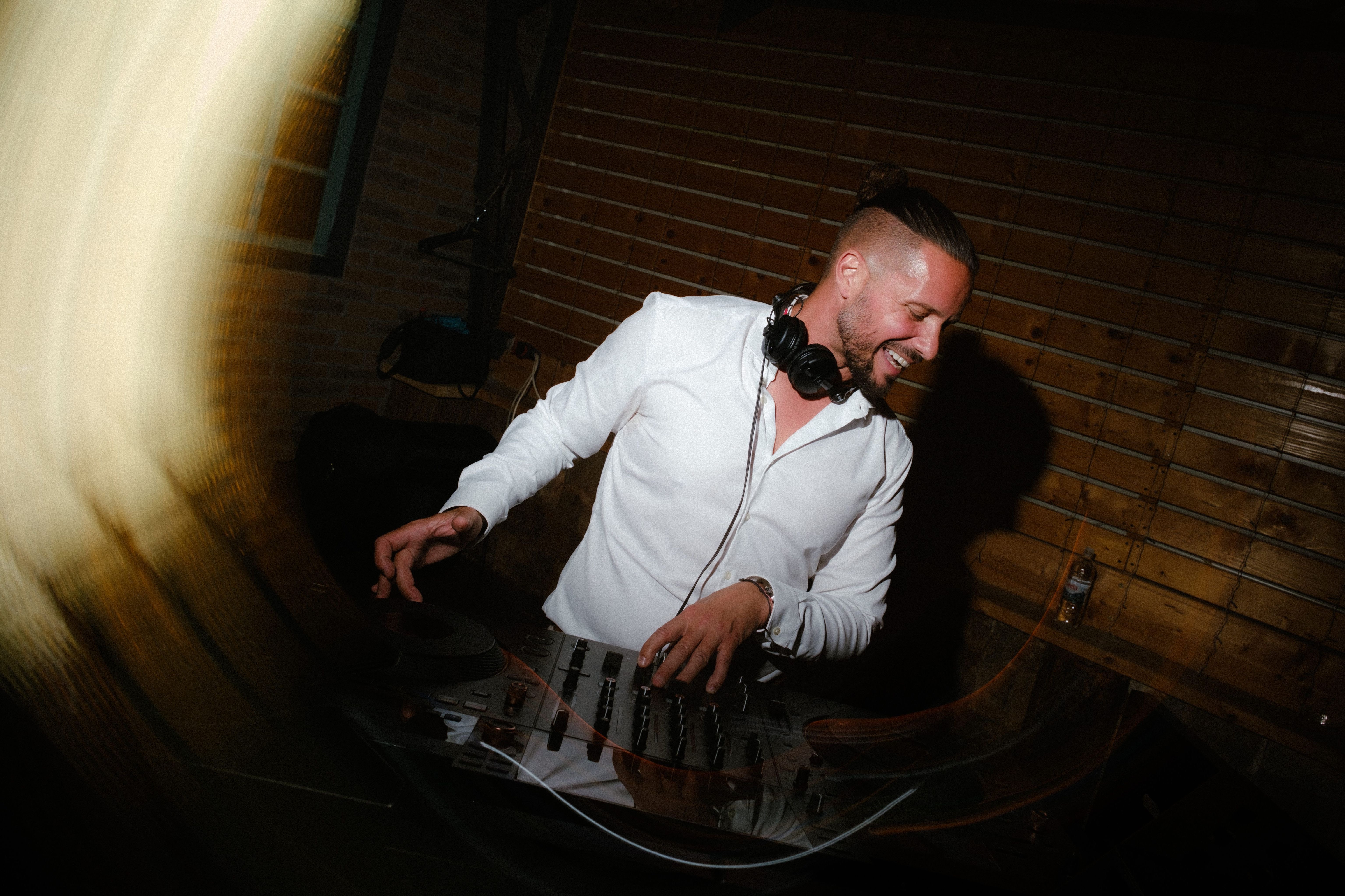 Luca smiling behind the decks in evening light