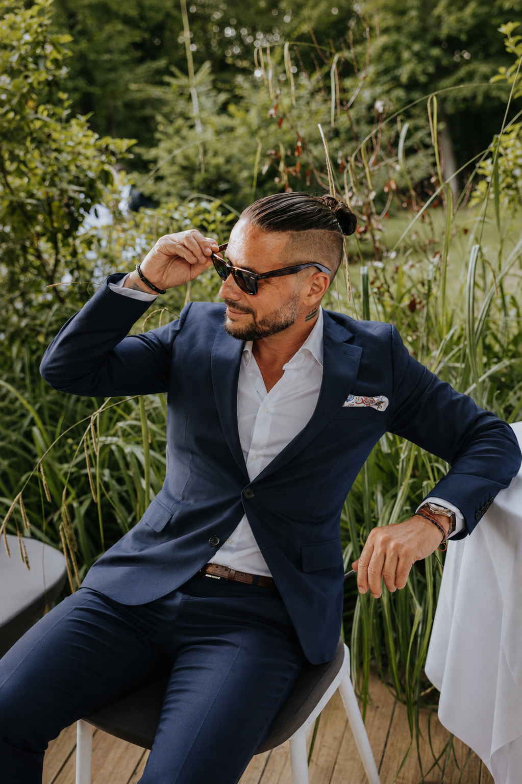 Luca relaxing in a blue suit in a garden